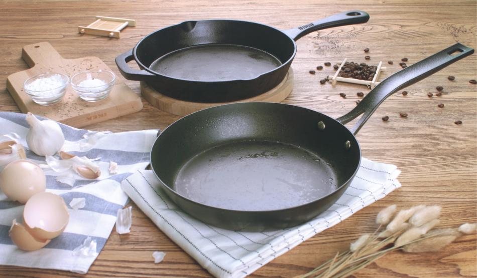two pans, garlic and seasonings on the table
