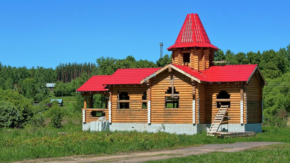 the red roof of the house with the green meadows