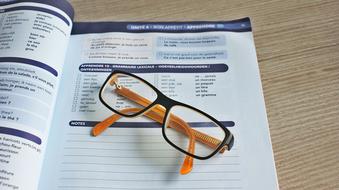 black and yellow glasses on the educational book