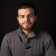 Portrait of the man with beard and moustache, in light, at dark background