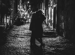 monochrome photo of kissing couple on street