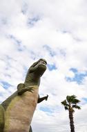 dinosaur sculpture by a tree