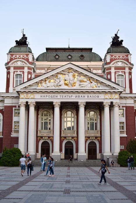 people on the background of the theater building in Sofia, Bulgaria