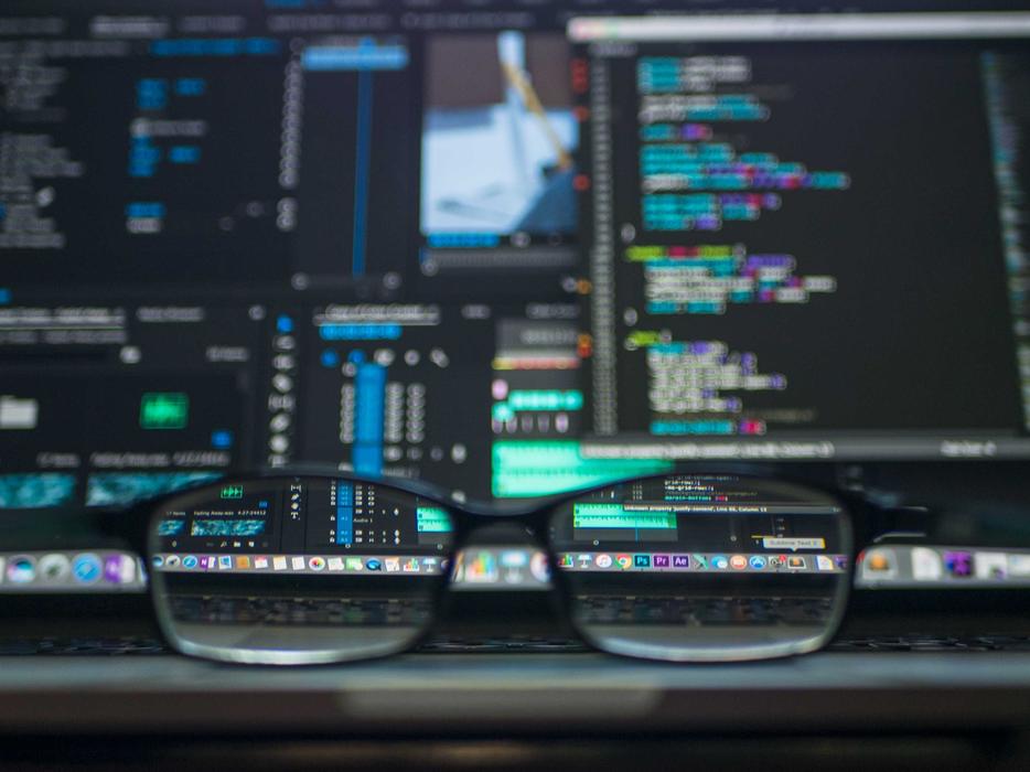 glasses on the background of computer analysis on the screen