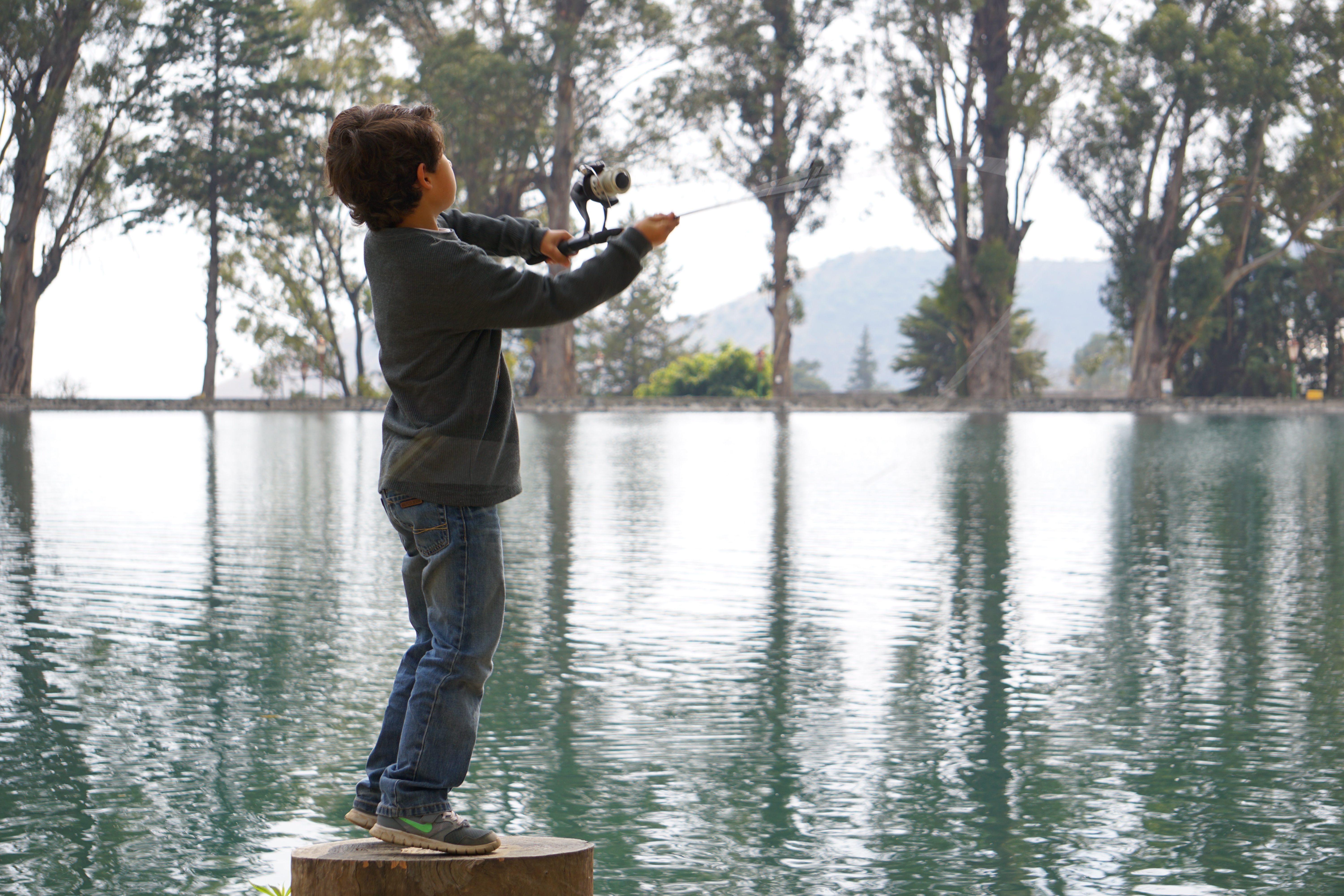 Детка ловли лав. Дети на рыбалке. Мальчик ловит рыбу. Дети ловят рыбу. Троста на озере.