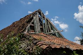 Old lapsed red tile Roof at sky