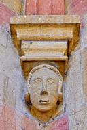 stone man's face on the fence