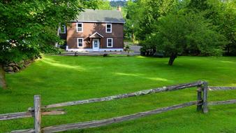 green meadow with a fence at the house