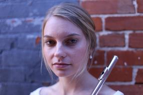 young girl with Flute at brick wall