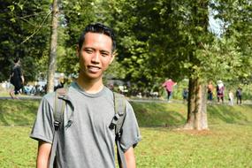 smiling student with backpack outdoors