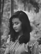 Black and white portrait of the cute, Asian girl among the plants