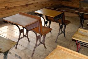 Shiny, colorful, antique wood desks, near the wooden wall, in the school