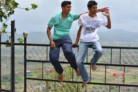 young tanned guys sit on the fence