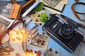 camera, glasses, keys and retro photo on the table