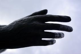 hand sculpture on cloudy sky background, close-up