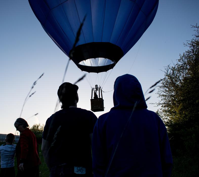 People looking at hot air Balloon at dusk