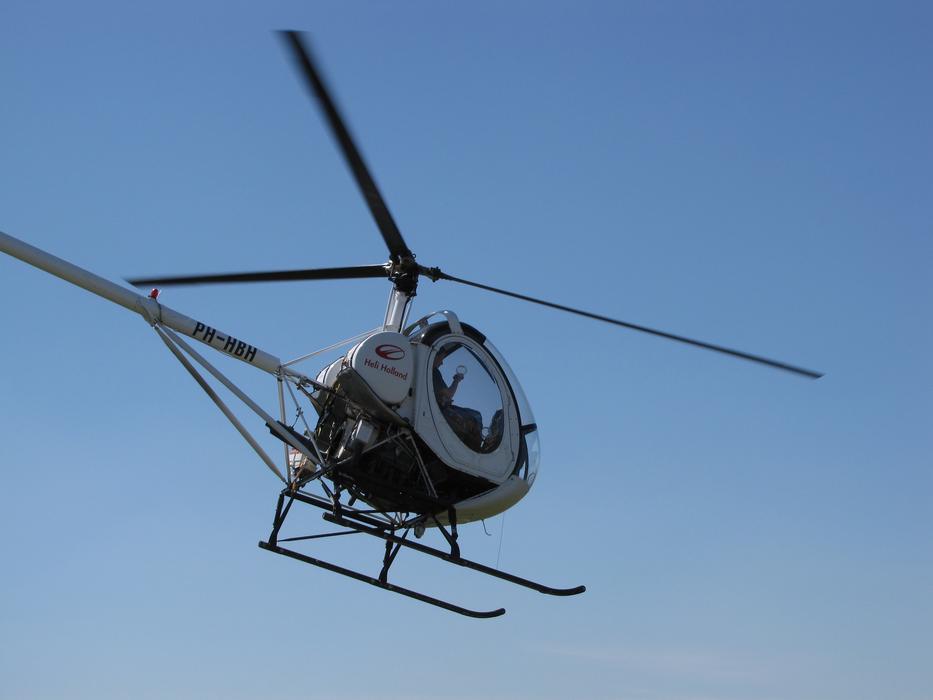 modern helicopter in flight in the blue sky
