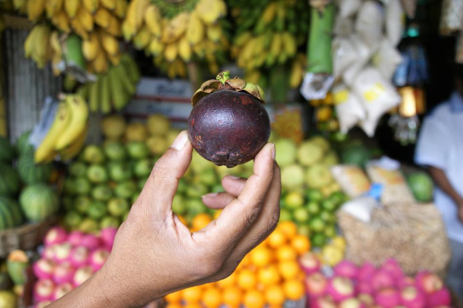 fresh fruit in hand against background of market