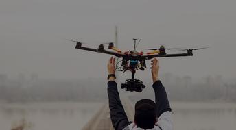 Person, with the colorful, flying drone, on the foggy landscape