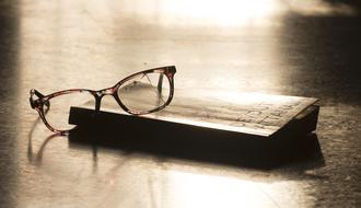 Retro photo with the eyeglasses, on the book, in light