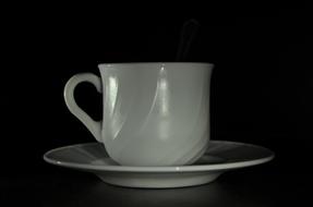 white cup on black background