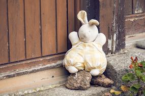 Cute and beautiful child toy of rabbit, near the construction and plant