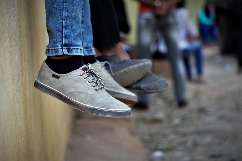Close-up of the shoes of sitting people together