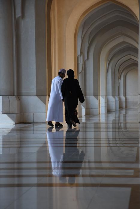the couple walks by the archway view