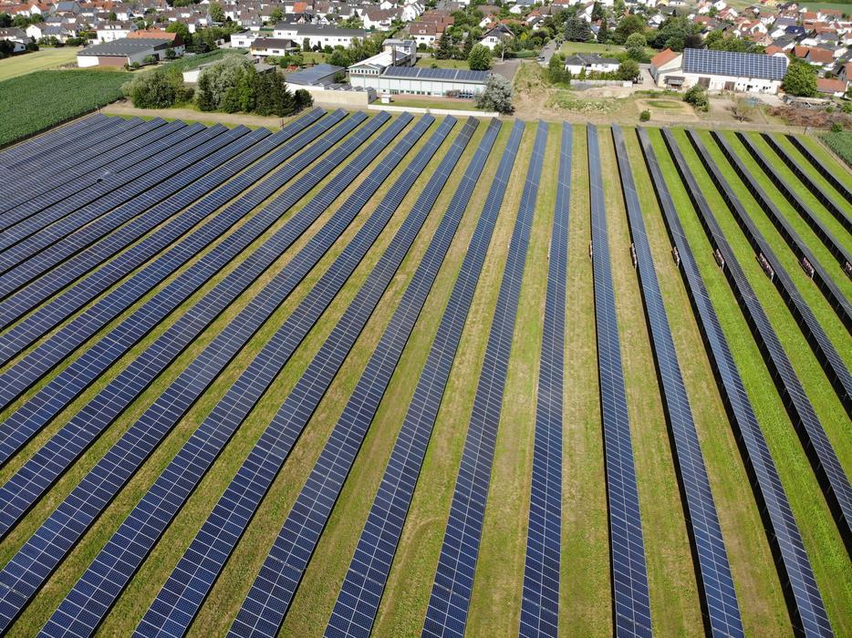 Beautiful green field with solar system near the buildings