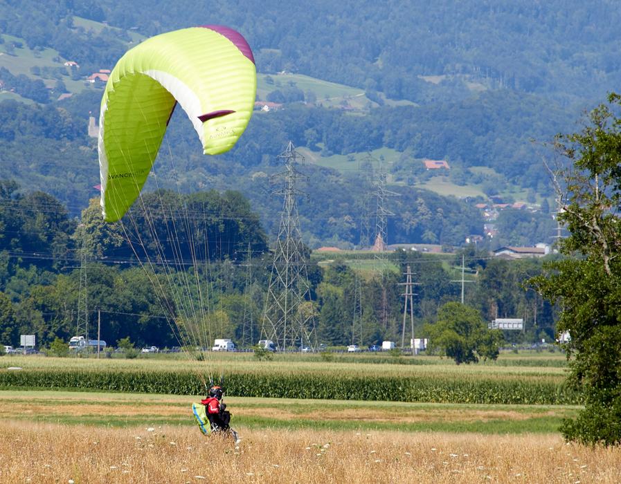 Man landing after the paragliding, among the plants