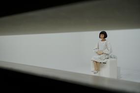 Robot girl, sitting on the white construction, in Japan