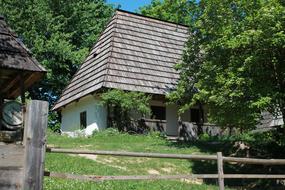 an old house by the side of the road with grass