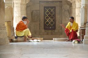 People in colorful robes, sitting in the building in India