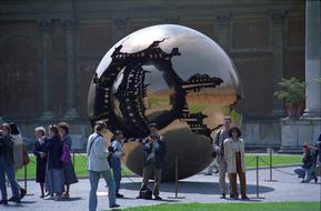 People near the shiny ball in the Vatican Museum