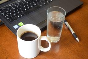 hot coffee and water by the computer