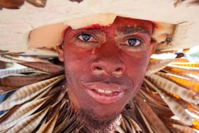 man with makeup wearing a hat at the carnival