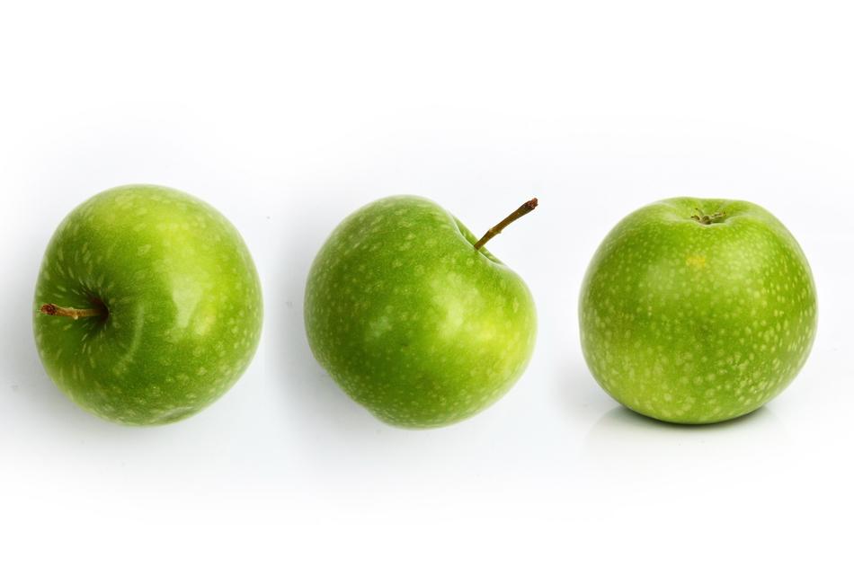 Three green apples on a white background