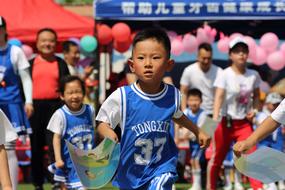 a little boy in a blue uniform