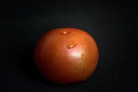 tomato with water drops on a black background