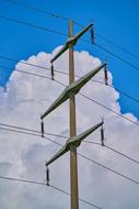 Power poles, with the cables, at blue sky background with clouds