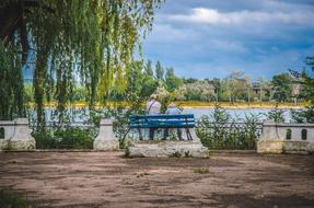 a blue bench with a lake view