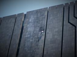 window cleaner working on gray modern building