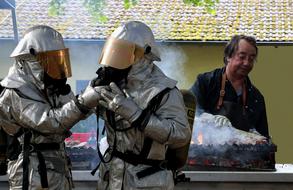 people in hazmat suits near the meat roaster