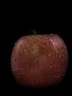 wet apple on black background