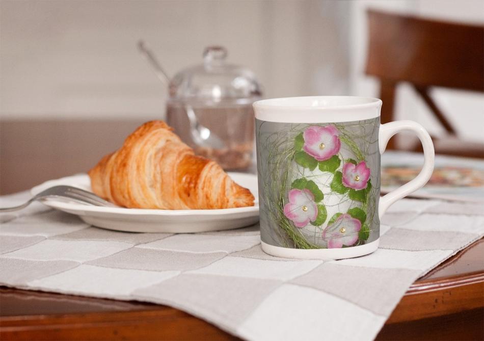 beautiful mug with a picture of flowers and a croissant