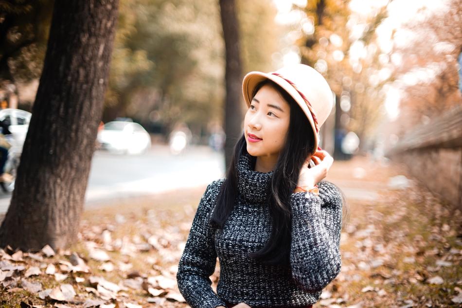 Portrait of the Asian girl in hat, among the beautiful plants