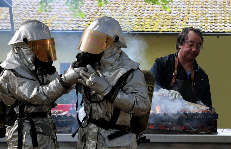 people in hazmat suits near the meat roaster