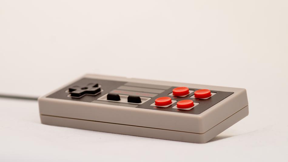 Game controller with black and red buttons and wire