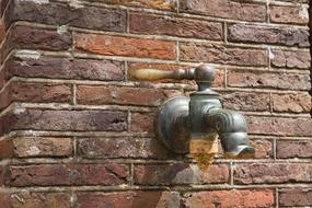 a faucet in a stone wall