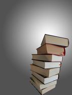 stack of thick books at grey background